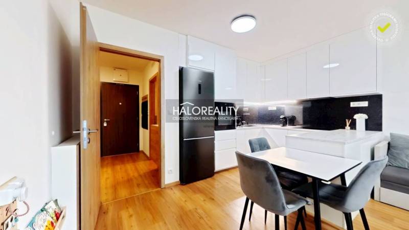 Küche in einer 2-Zimmer-Wohnung mit Esstisch, Einbauküche und Bodenbelag in Holzoptik.