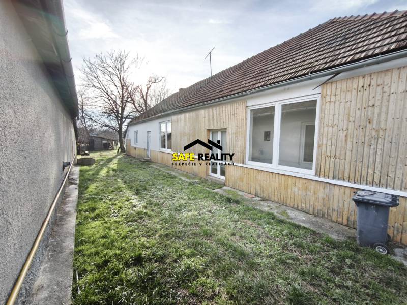 Ein Einfamilienhaus in Lúčnica nad Žitavou mit Holzverkleidung und Garten.