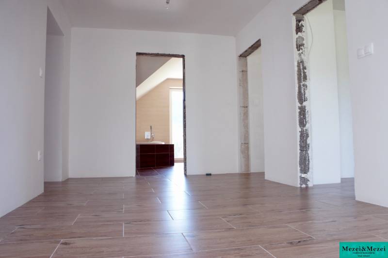 Innenraum eines Einfamilienhauses mit Holzboden und unbedeckten Bauöffnungen.