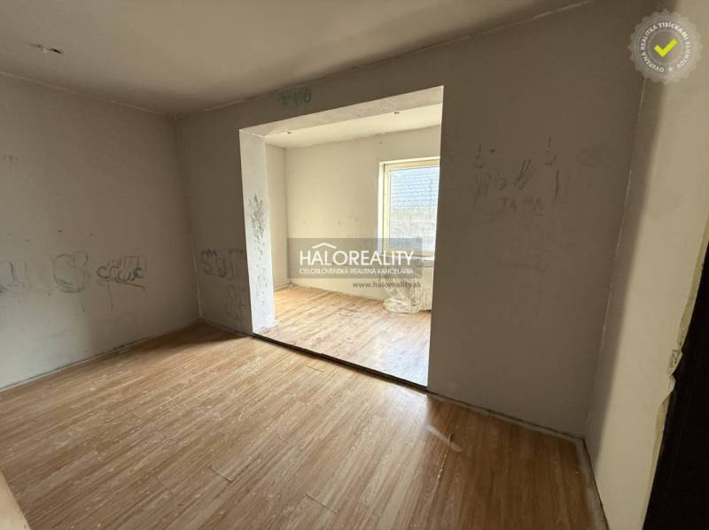 Izba v rodinnom dome s podlahou s dreveným dekorom a nápismi na stenách.