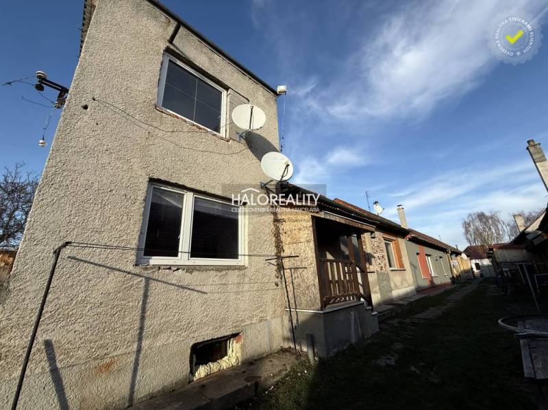 Ein Einfamilienhaus in Chynorany mit Satelliten und Garten, nebenan weitere Häuser.