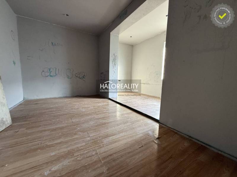 Ein Zimmer in einem Einfamilienhaus mit einem Holzboden und schlichten Wänden.