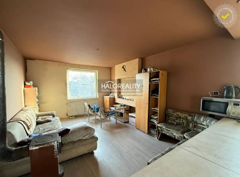 Wohnzimmer mit Sofa, Möbeln und Küchenzeile in einem Einfamilienhaus.