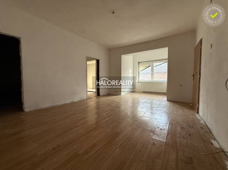 Innenraum eines Einfamilienhauses mit Holzboden und großem Fenster.