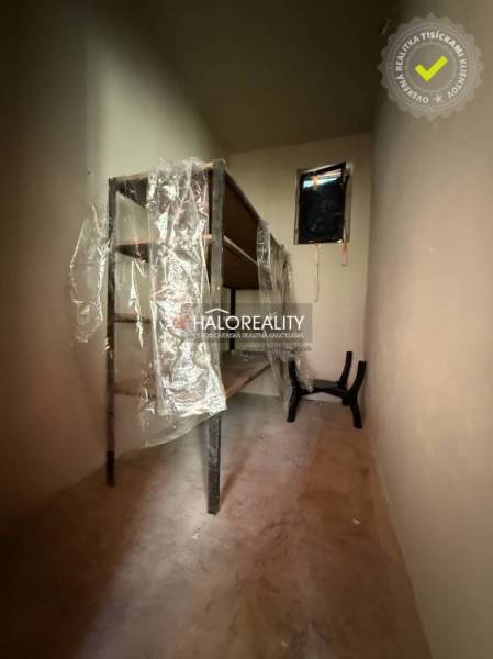 Ein enger Lagerraum mit Regalen und Plastikverpackung in einem Einfamilienhaus.