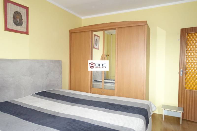 Schlafzimmer mit Bett, Kleiderschrank und Dekoration in einer 3-Zimmer-Wohnung.