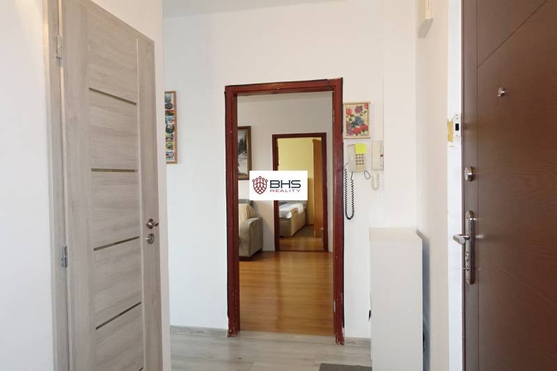 Der Flur in der 3-Zimmer-Wohnung mit einem Boden in Holzoptik und einer Gegensprechanlage.