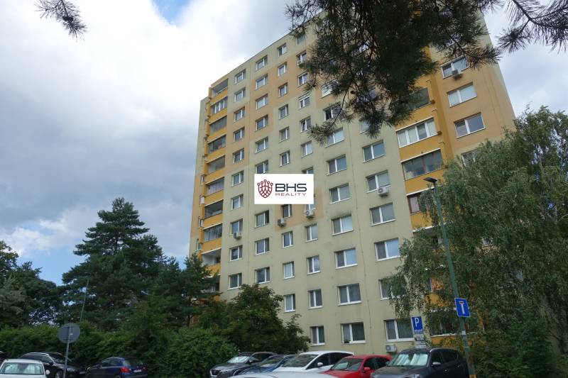 Ein Wohnhaus in Bratislava-Dúbravka in der Homolova-Straße, umgeben von Bäumen und einem Parkplatz.