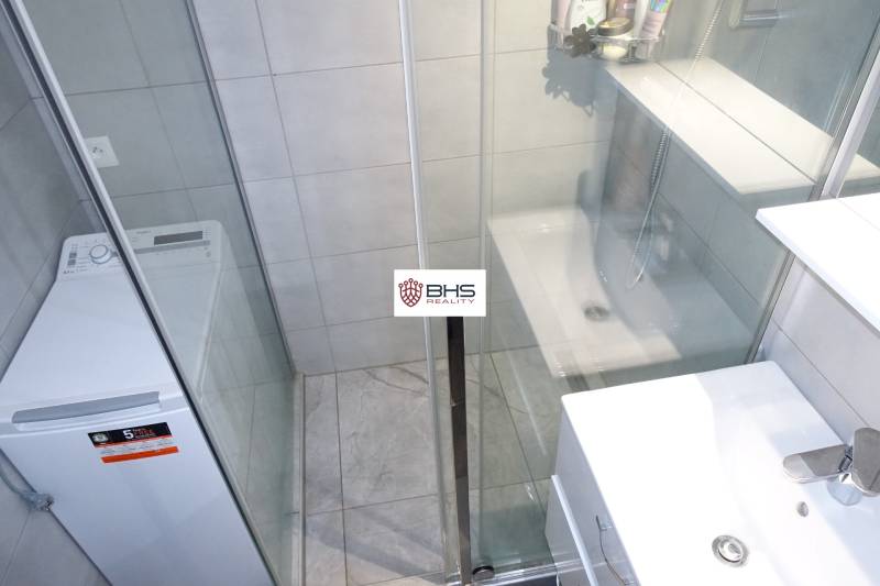 Badezimmer mit Duschkabine und Waschmaschine in einer 3-Zimmer-Wohnung.