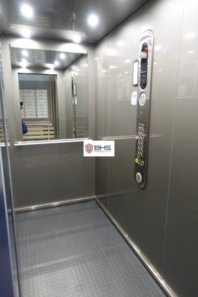 Der Innenraum des Aufzugs mit Bedienfeld und Spiegel in einer 3-Zimmer-Wohnung.