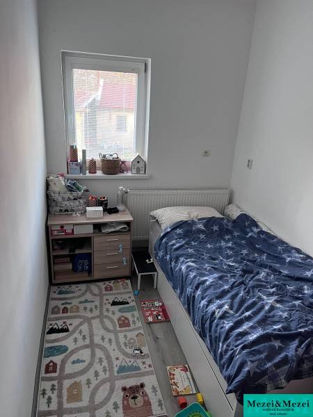 Kinderzimmer mit Bett, Fenster und Teppich in einer 4-Zimmer-Wohnung.