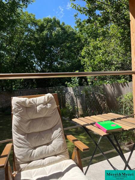 Entspannung auf der Terrasse eines Hauses in Bratislava - Vrakuňa mit Liegestuhl und Tisch unter blauem Himmel.