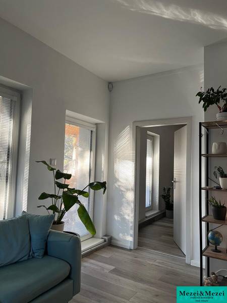 Helles Wohnzimmer mit Pflanzen, Sofa und Holzdekorboden in einer 4-Zimmer-Wohnung.