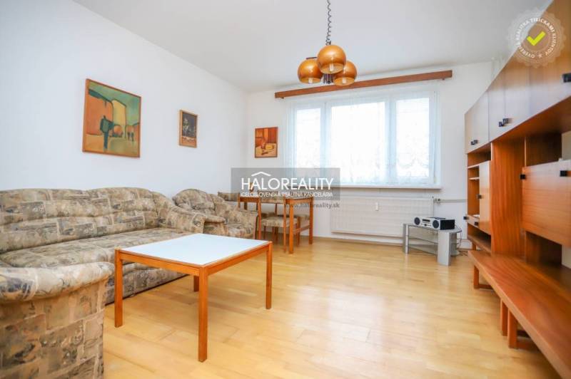 Wohnzimmer in einer 3-Zimmer-Wohnung mit Holzboden, Sofa und Möbeln.