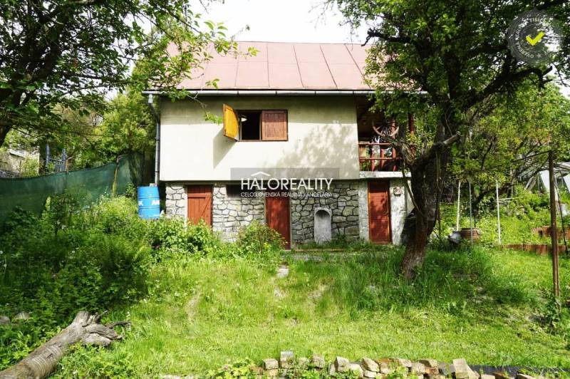 Ein gemütliches Häuschen, umgeben von üppigem Grün und Bäumen in einer natürlichen Umgebung.