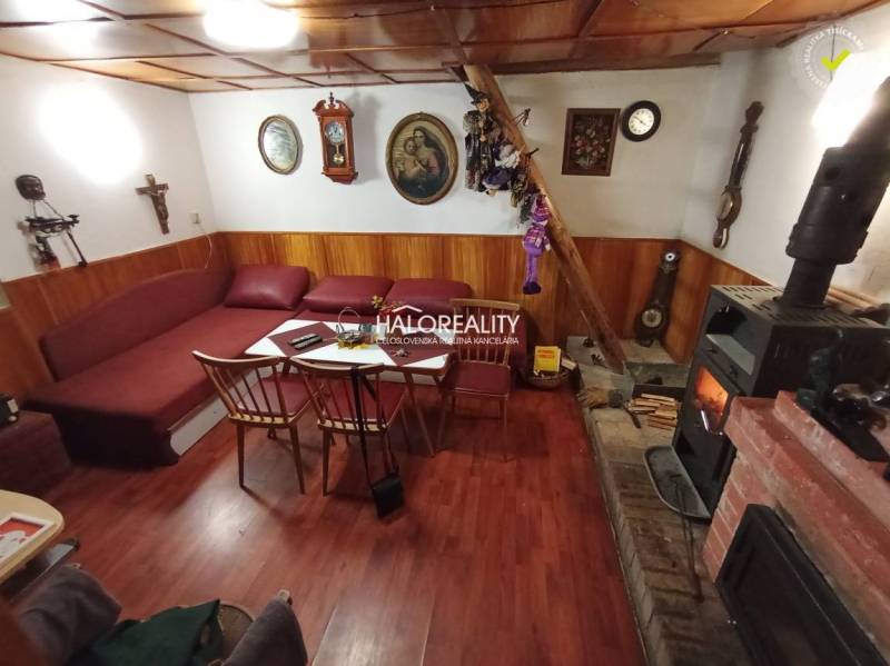 Rustikale Hütte, Holzbalkendecke, Kamin, bequeme Sitzgarnitur, traditionelles Interieur, angenehme Atmosphäre.