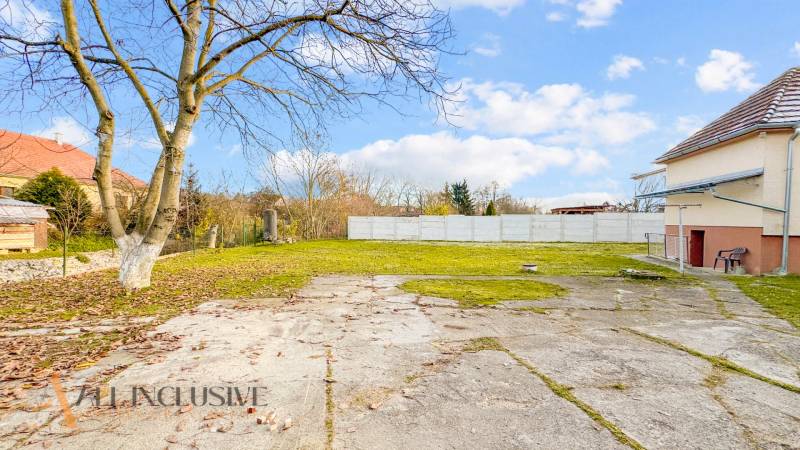 Ein Hof bei einem Einfamilienhaus in der Nemečkovská-Straße in Prašice mit gepflasterter Fläche und Bäumen.