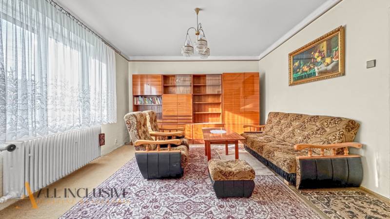 Wohnzimmer in einem Einfamilienhaus mit Teppichen, Möbeln und Sesseln, mit einem dekorativen Bild.