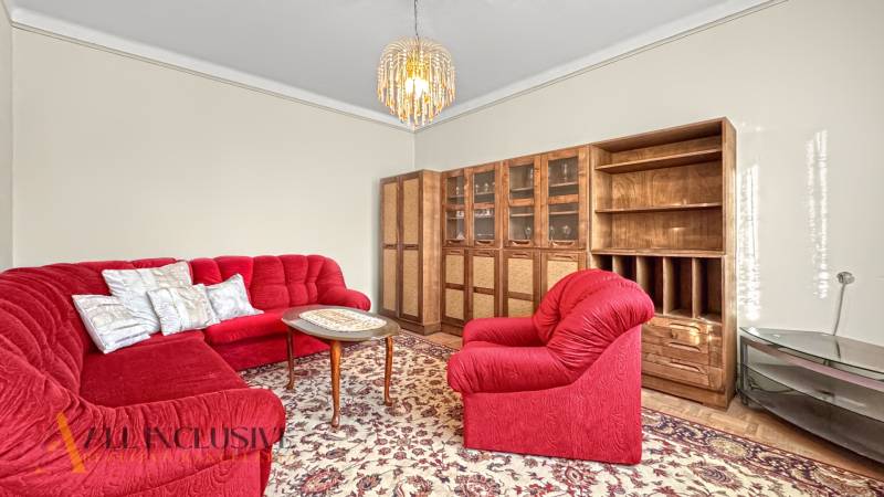 Wohnzimmer eines Einfamilienhauses mit rotem Sofa und Holzmöbeln.