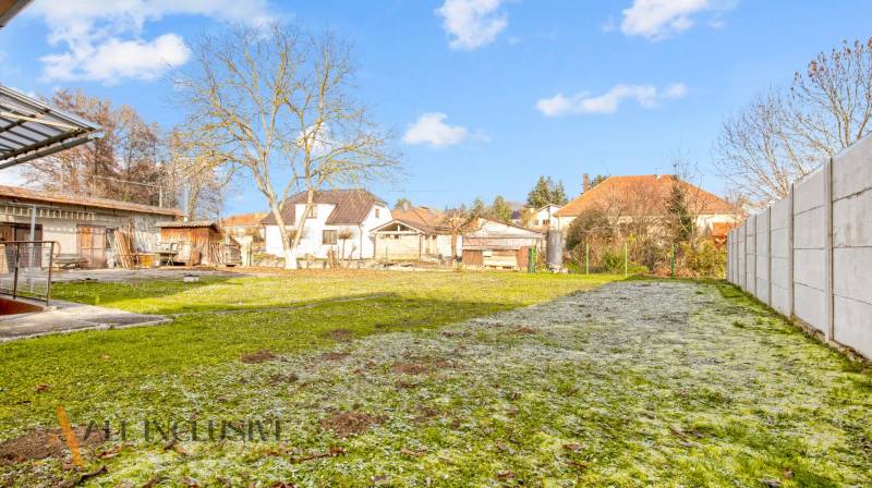 Der Garten beim Einfamilienhaus in der Nemečkovská-Straße in Prašice mit Bäumen und Rasen.