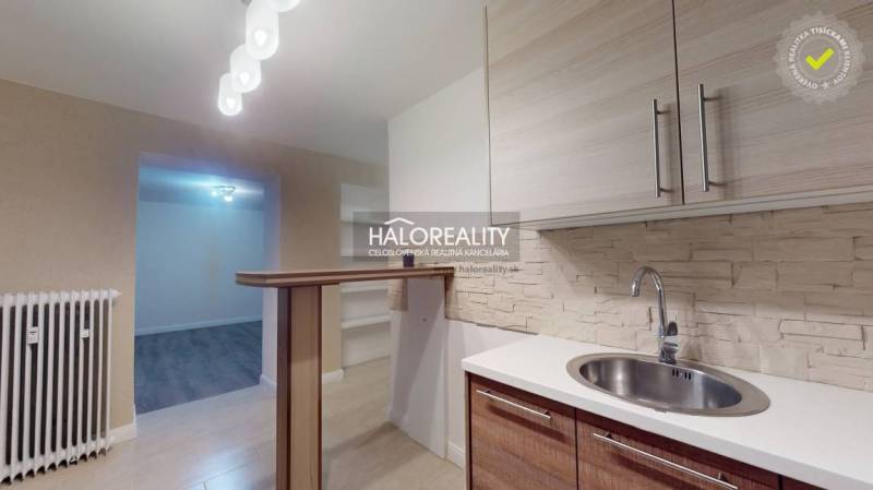 Küche einer 2-Zimmer-Wohnung mit Holzboden und Bartresen.