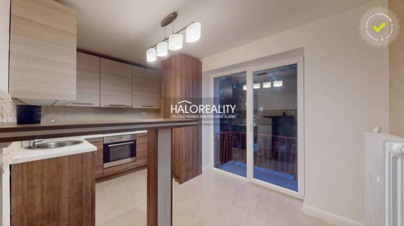 Küche in einer 2-Zimmer-Wohnung mit Holzboden und Zugang zum Balkon.