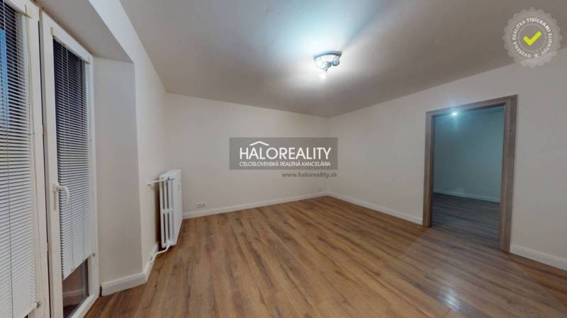 Geräumiges Zimmer in einer 2-Zimmer-Wohnung mit Holzboden und Heizkörper.