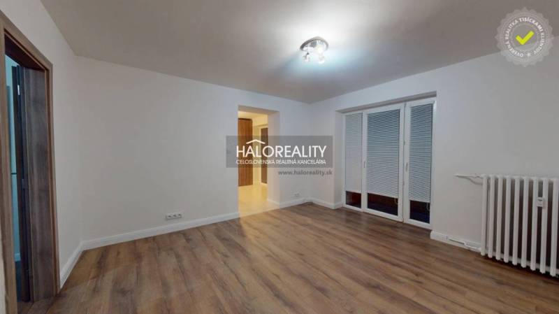 Wohnzimmer in einer 2-Zimmer-Wohnung mit Holzboden und französischem Fenster.