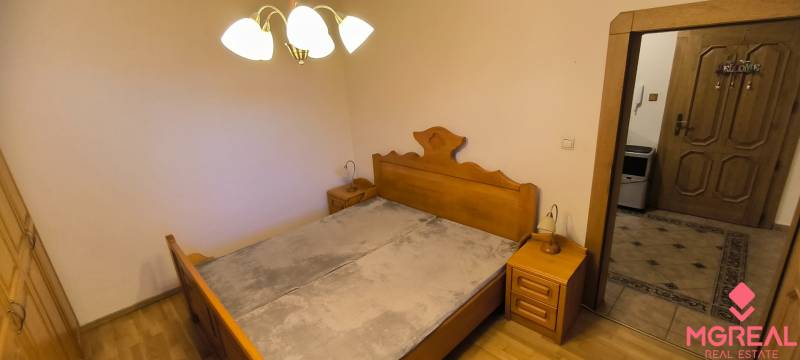 Schlafzimmer in einer 3-Zimmer-Wohnung mit Holzelementen und Nachttischen.