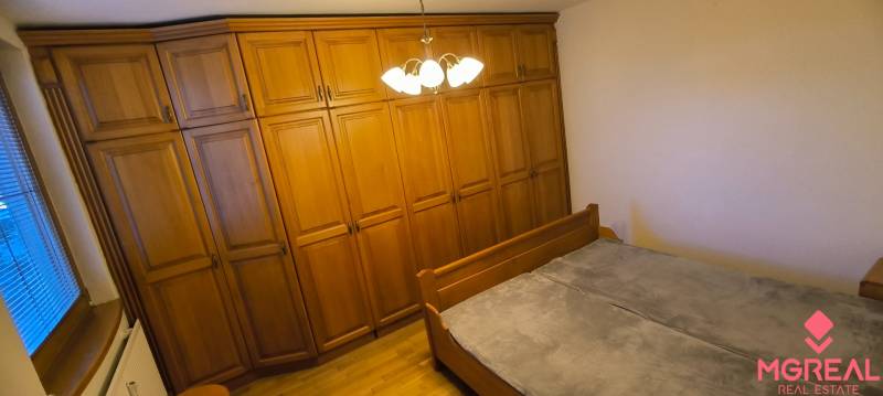 Schlafzimmer in einer 3-Zimmer-Wohnung mit einem großen Kleiderschrank und einem Bett.