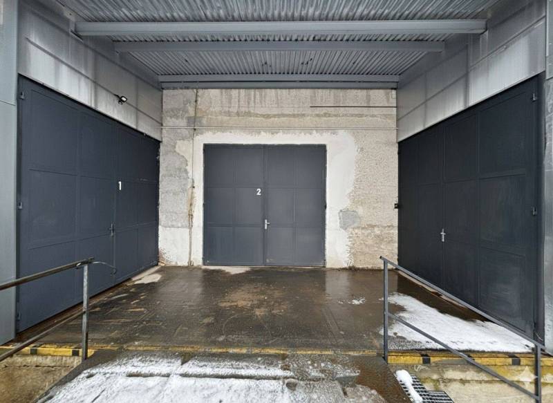 Drei Garagentore mit Metallzaun in den Büros in Poprad.