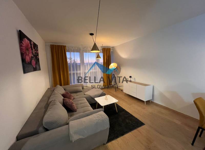 Wohnzimmer in einer Zweizimmerwohnung mit Sofa und Holzboden.