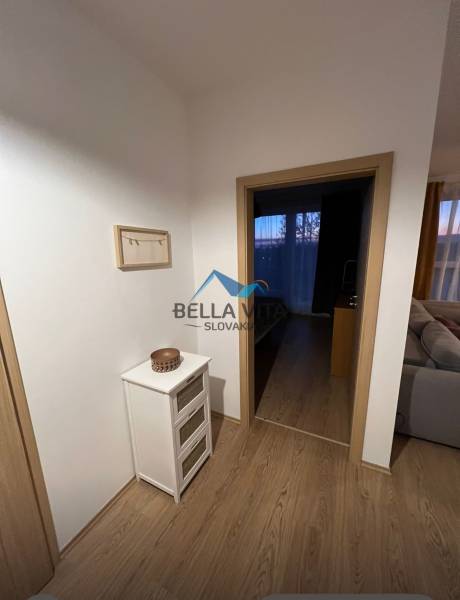 Innenraum einer 2-Zimmer-Wohnung mit Holzboden, hellem Möbeln und Dekorationen.