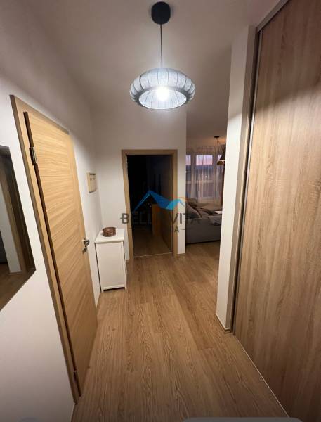 Flur in einer 2-Zimmer-Wohnung mit Holzboden und einfacher Beleuchtung.