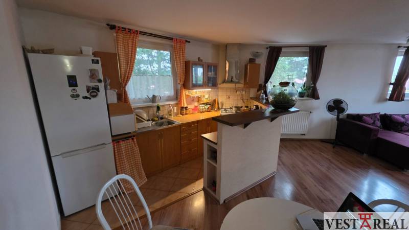 Küche in einer 3-Zimmer-Wohnung mit Holzboden und Esstisch.