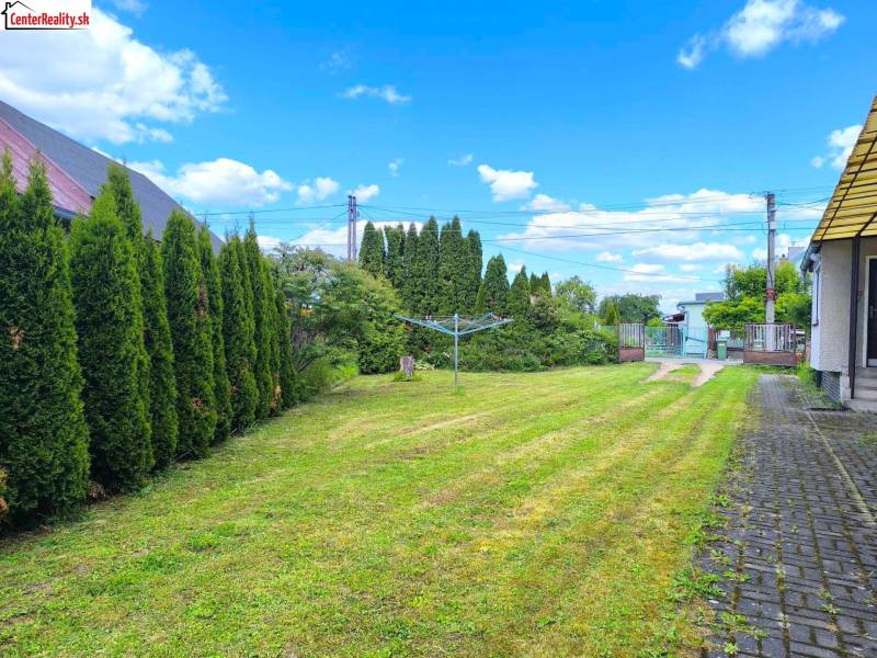 Gartenfläche eines Einfamilienhauses in Prievidza mit sorgfältig gepflegtem Rasen und Hecke.
