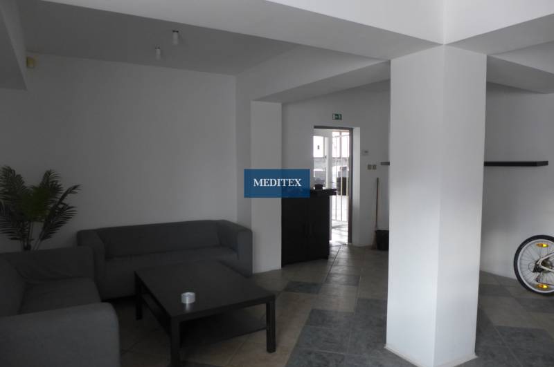 Wohnbereich mit grauen Sofas, Couchtisch und Fliesenboden in Lagerhäusern und Hallen.