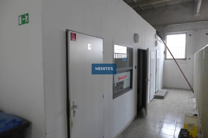 Innenraum mit weißen Türen und grauen Wänden in Lager- und Hallenräumen.