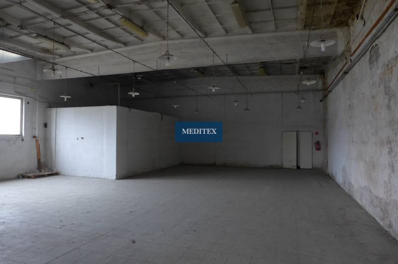 Industrielles Interieur eines Lagers mit hoher Decke und Betonboden.