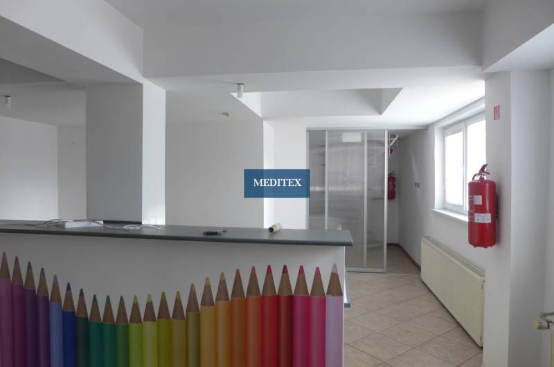 Innenraum von Lagern und Hallen mit einem Empfangstresen, der mit bunten Bleistiften und einem Feuerhydranten dekoriert ist.