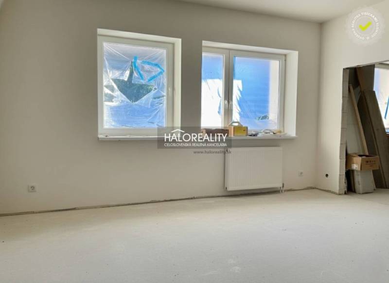 Ein Zimmer in einem Einfamilienhaus mit Fenstern und Heizkörper, ungenutzter Raum bereit zur Fertigstellung.