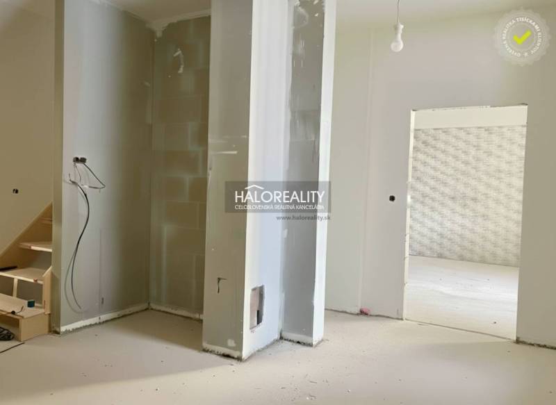 Unvollendete Renovierung eines Einfamilienhauses mit freiliegenden Wänden und einer Öffnung für die Treppe.