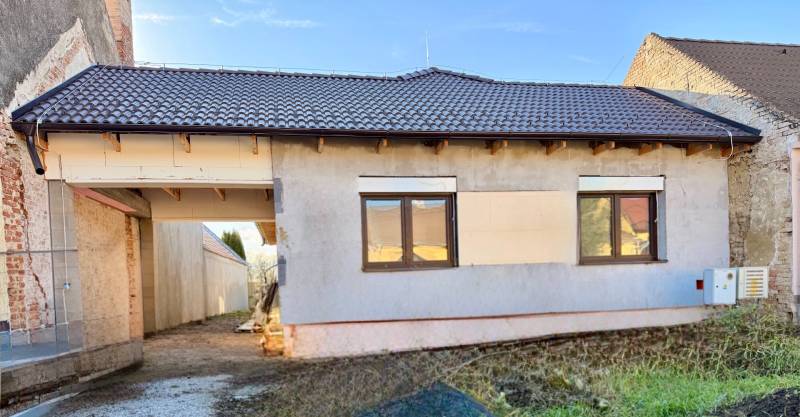 Ein Einfamilienhaus in Cífer mit einer unverputzten Fassade und einer braunen Dacheindeckung.