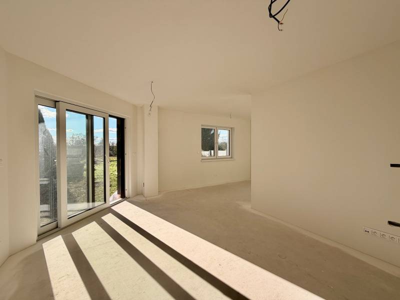 Geräumiges Zimmer mit großen Fenstern und Aussicht in einem Einfamilienhaus.