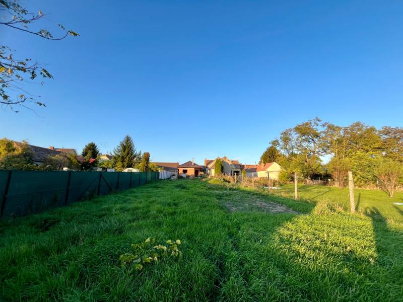 Grundstück mit Rasenbewuchs und Umzäunung in Cífer bei Einfamilienhäusern.