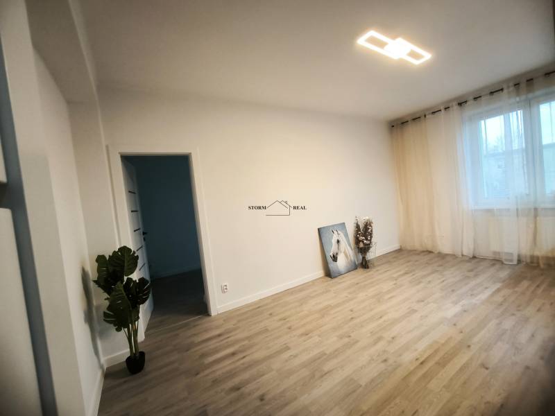 Ein Zimmer mit Vorhängen und einem Boden in Holzoptik in einer 4-Zimmer-Wohnung.