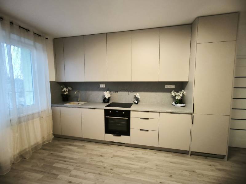 Küche in einer 4-Zimmer-Wohnung mit Holzboden und hellen Möbeln.