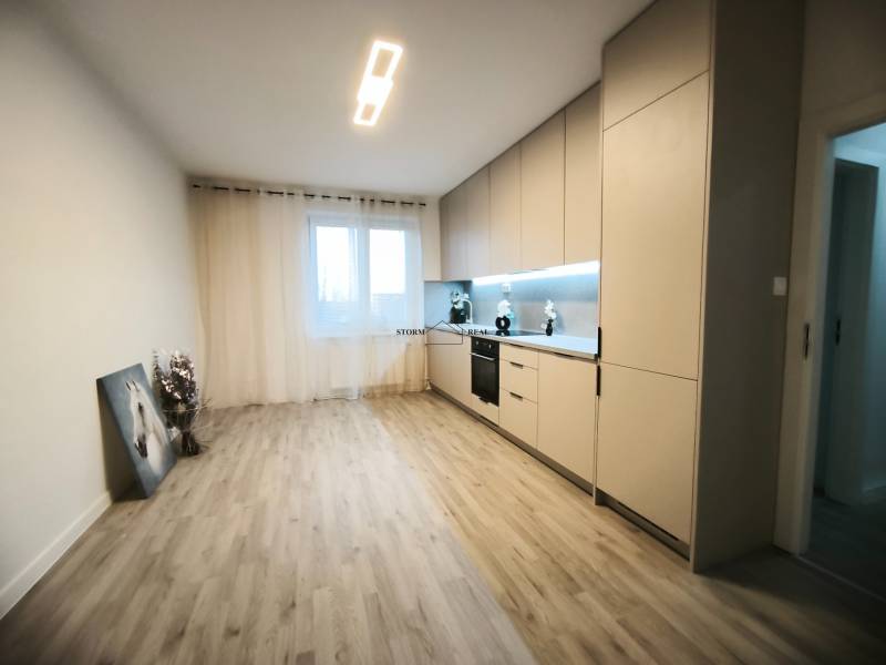 Küche in einer 4-Zimmer-Wohnung mit Holzboden und eingebauten Geräten.