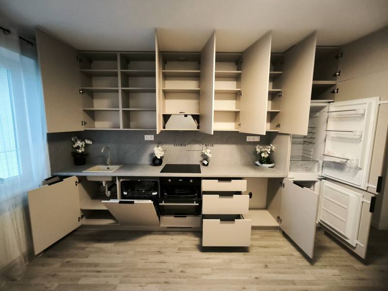 Küche in einer 4-Zimmer-Wohnung mit Holzboden, offenen Regalen und Geräten.