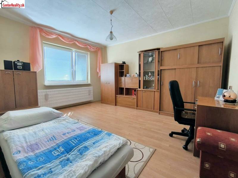 Schlafzimmer in einem Einfamilienhaus mit Holzboden, Möbeln und Bett.